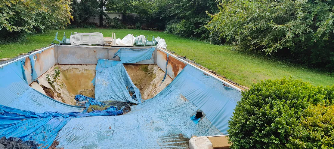 Old pool with torn and faded blue liner needing replacement