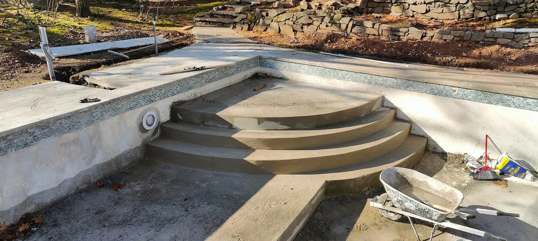 Newly formed curved concrete walk-in steps in a pool