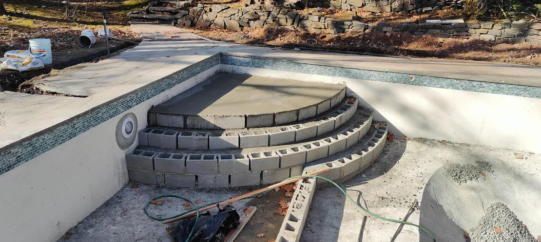 Tiled curved walk-in steps under construction with cinder blocks