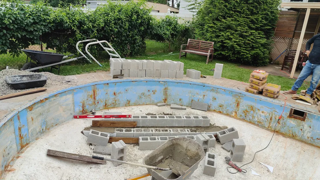 Cinder block step framing being built in an empty pool