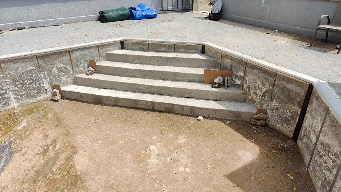Completed concrete walk-in steps in an empty pool